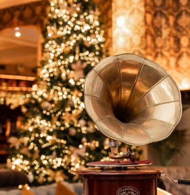 Elegant hotel lobby with vintage gramophone and festive Christmas tree, creating a warm and inviting atmosphere for guests.