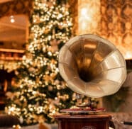 Elegant hotel lounge with vintage gramophone and festive Christmas tree casting a warm, inviting glow.
