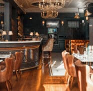Elegant hotel restaurant with vintage chandeliers, plush seating, and refined decor, offering a cosy dining experience.