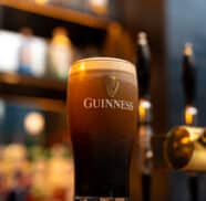 Pint of Guinness on elegant hotel bar, with soft lighting creating a cosy atmosphere, inviting guests to unwind.