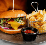 Delicious gourmet burger with melted cheese and crispy fries, perfect for a satisfying meal at our luxury hotel restaurant.