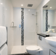 Spacious hotel bathroom with modern shower, plush towels, and elegant decor for a relaxing guest experience.