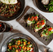 Vibrant dining spread with gourmet salads and artisanal breads on elegant stoneware, showcasing hotel restaurant's culinary delights.