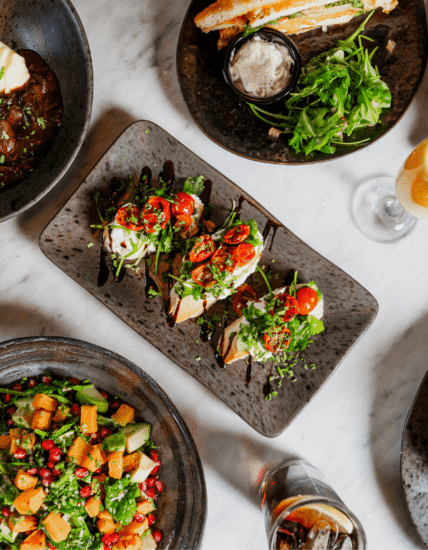 Gourmet dishes and drinks at hotel restaurant with fresh salads, exquisite desserts, and stylish presentation.